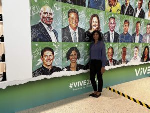 Dr. Nishi Rawat stands in front of speaker display wall