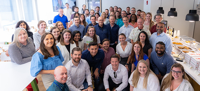 Group of Bamboo Health employees smiling in the office kitchen
