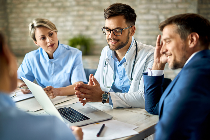 Team of doctors and businessman using computer during the meeting in the office